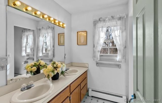 bathroom with a sink, a baseboard heating unit, and double vanity