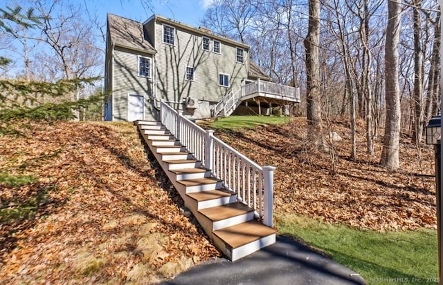 view of home's exterior featuring stairway and a wooden deck