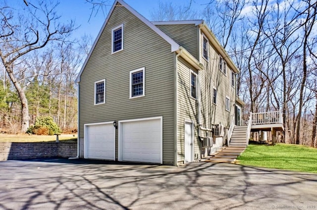 view of home's exterior featuring aphalt driveway, stairway, and a garage