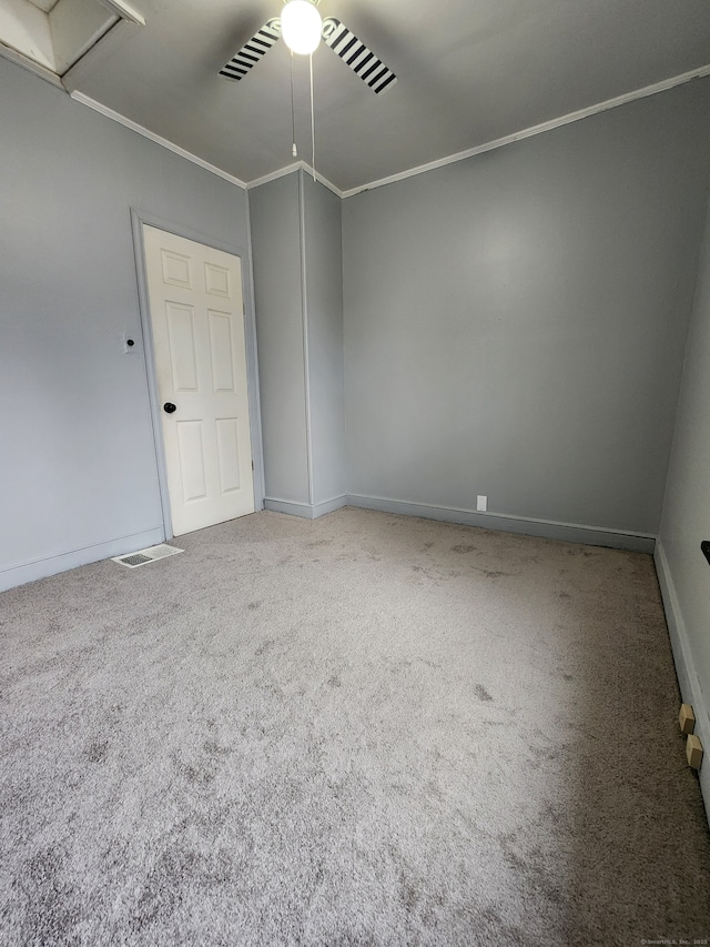 empty room featuring crown molding, baseboards, and carpet floors