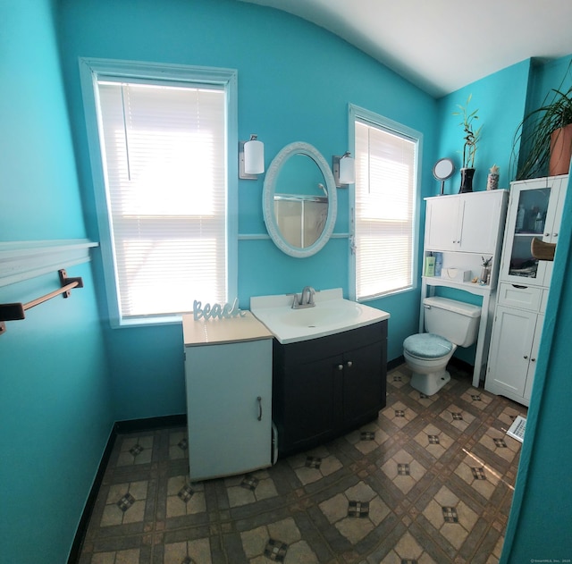 bathroom with tile patterned floors, a healthy amount of sunlight, toilet, and baseboards