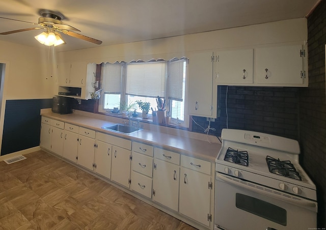 kitchen with visible vents, a sink, gas range gas stove, white cabinets, and light countertops