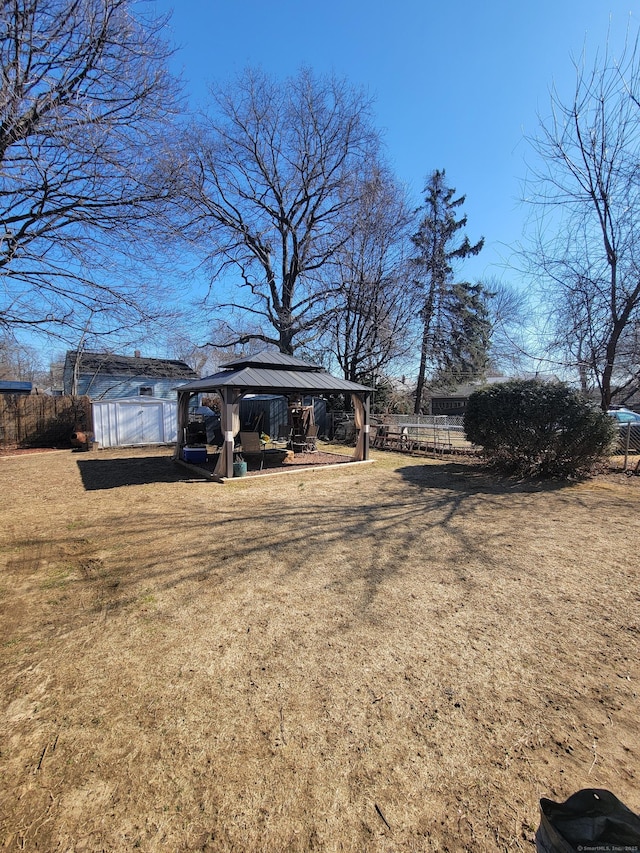 view of yard featuring a gazebo, a carport, and fence