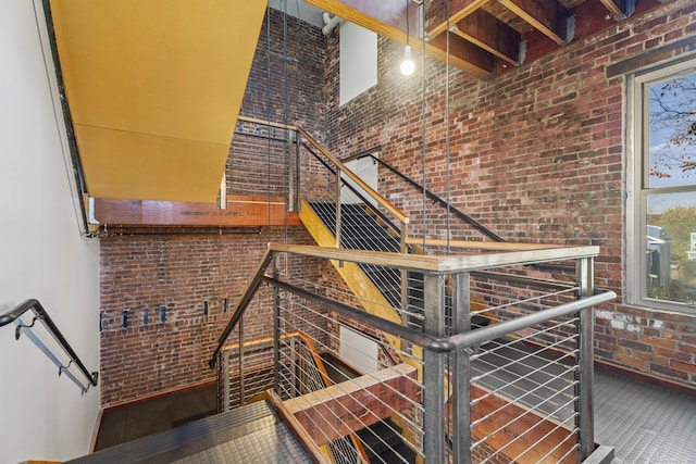 stairs with brick wall and a towering ceiling