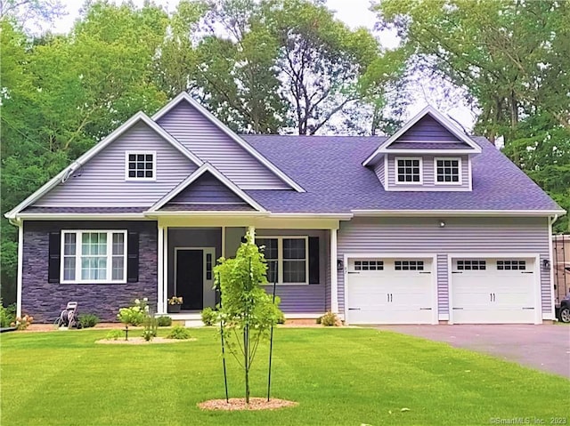 view of front of property featuring a front lawn, aphalt driveway, stone siding, roof with shingles, and a garage