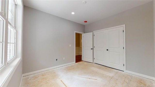 unfurnished bedroom featuring a closet and baseboards