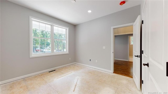 empty room featuring recessed lighting, baseboards, and visible vents