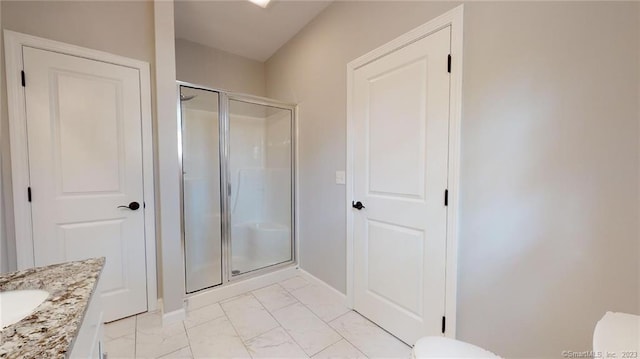 full bathroom with a shower stall, baseboards, toilet, marble finish floor, and vanity