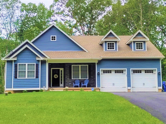 view of front of home featuring a porch, a front yard, roof with shingles, driveway, and an attached garage