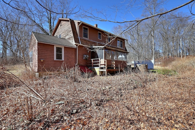 back of house with a chimney