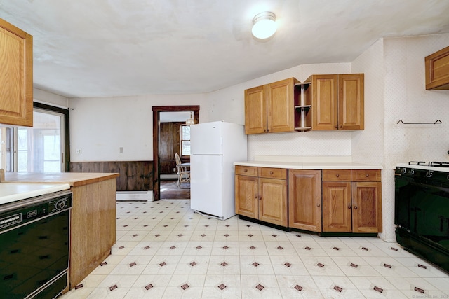 kitchen featuring a wainscoted wall, a baseboard heating unit, freestanding refrigerator, range with gas cooktop, and dishwasher