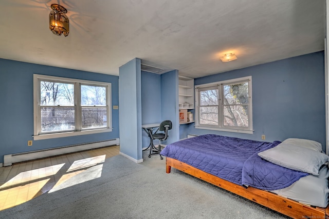 bedroom featuring a baseboard heating unit, multiple windows, baseboards, and carpet floors