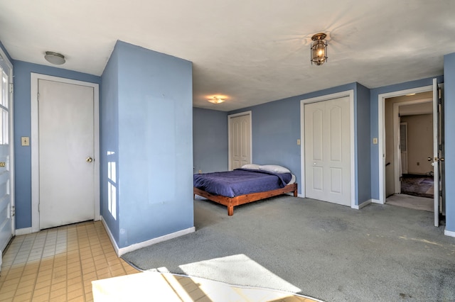 bedroom featuring two closets and baseboards