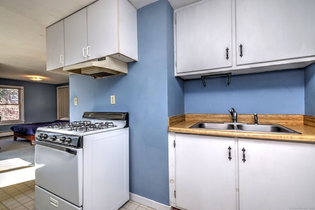 kitchen featuring under cabinet range hood, gas range gas stove, white cabinetry, and a sink