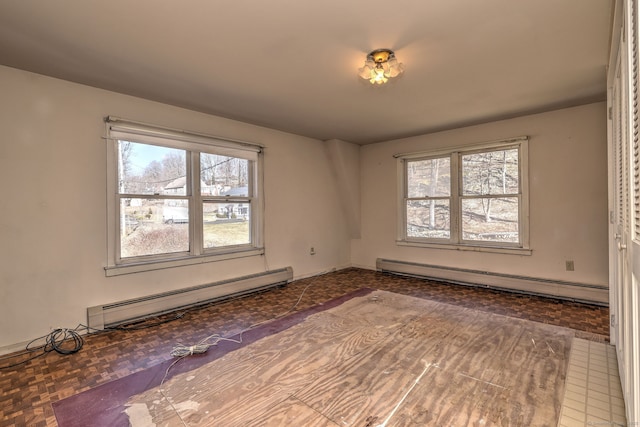 spare room with baseboard heating and a healthy amount of sunlight