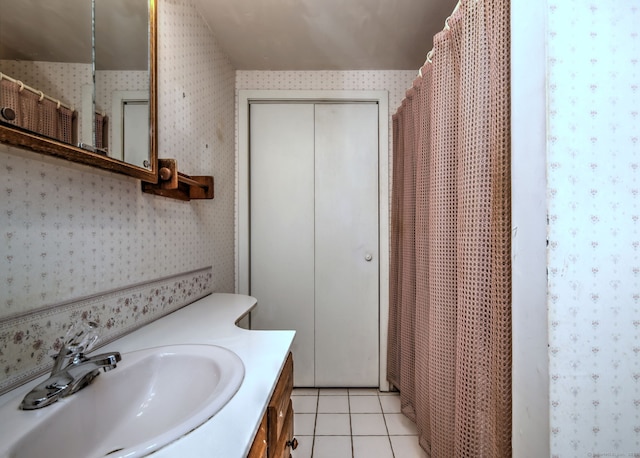 bathroom featuring vanity, tile patterned flooring, and wallpapered walls