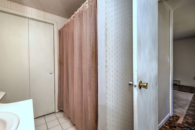 full bathroom with tile patterned floors and a baseboard heating unit