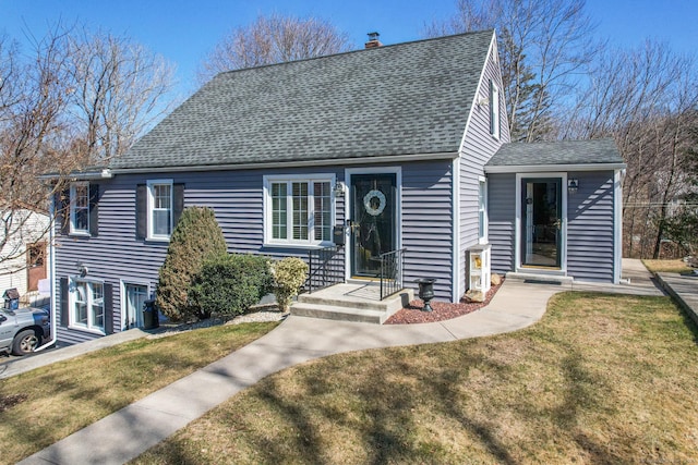 view of front facade featuring a front yard, roof with shingles, and a chimney