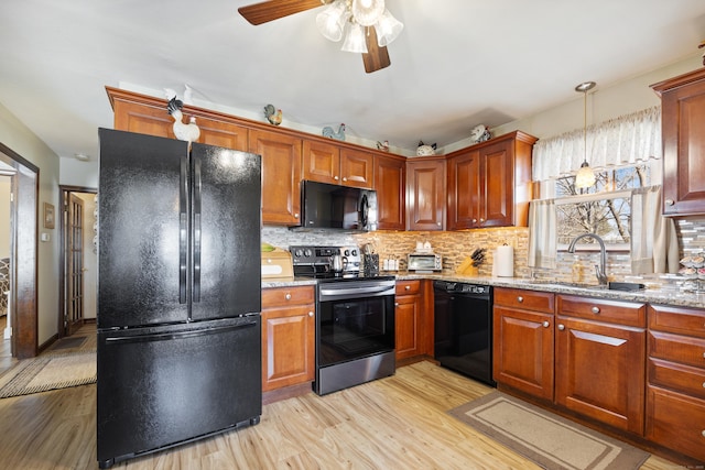 kitchen featuring backsplash, black appliances, and a sink