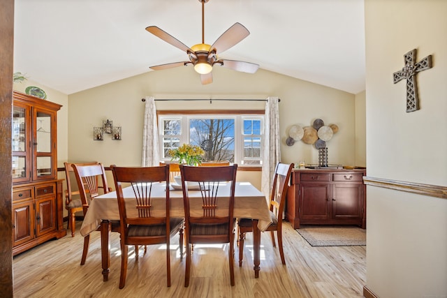 dining space with lofted ceiling, a ceiling fan, and light wood finished floors