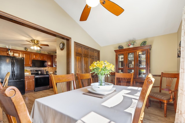 dining space with light wood-type flooring, lofted ceiling, and ceiling fan