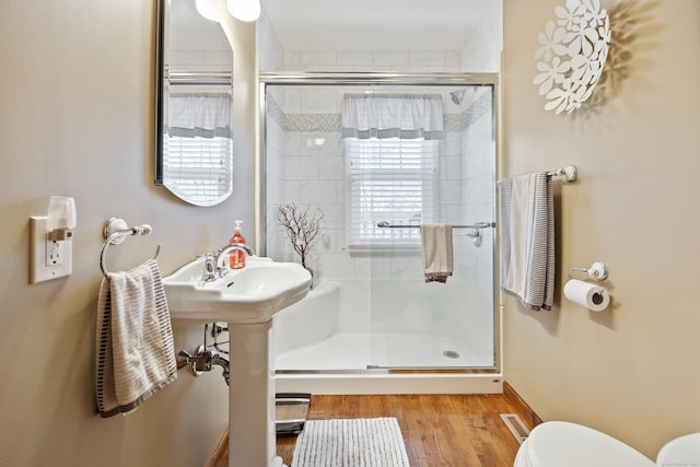 full bathroom featuring visible vents, toilet, wood finished floors, and a stall shower