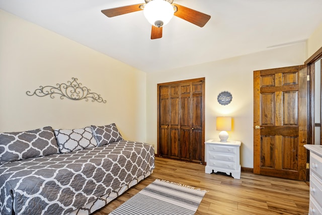 bedroom featuring a closet, ceiling fan, light wood-type flooring, and baseboards