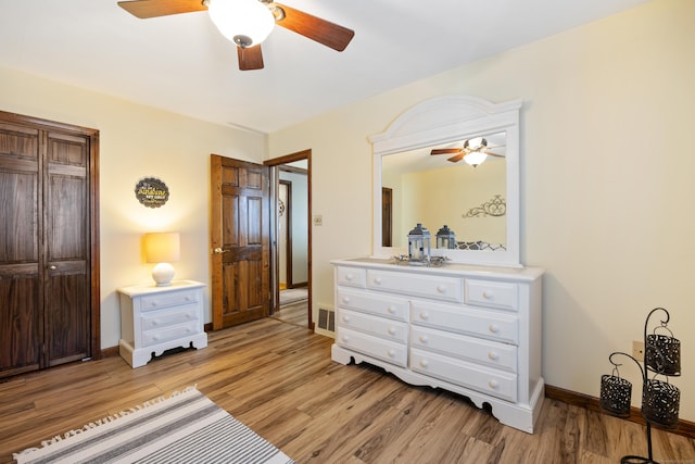 bedroom featuring visible vents, baseboards, ceiling fan, and light wood finished floors