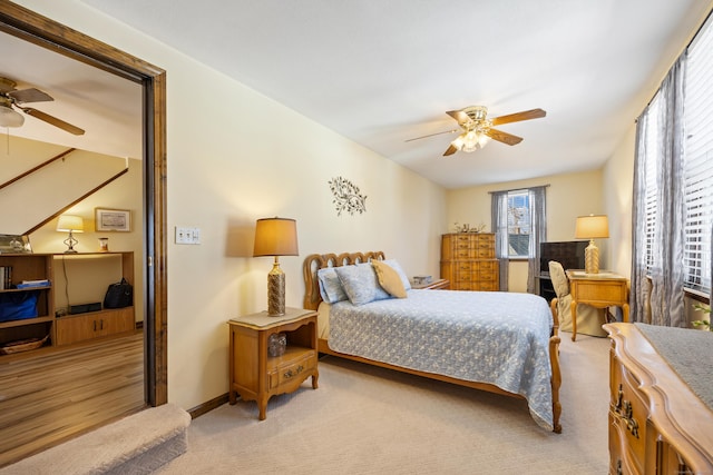 bedroom featuring baseboards, light carpet, and a ceiling fan