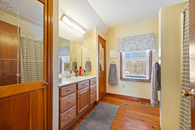 bathroom featuring vanity, a shower with curtain, wood finished floors, visible vents, and baseboards