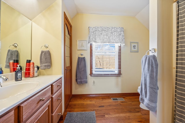 bathroom featuring visible vents, lofted ceiling, wood finished floors, and vanity