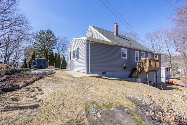 rear view of property with stairs, a chimney, and a shingled roof