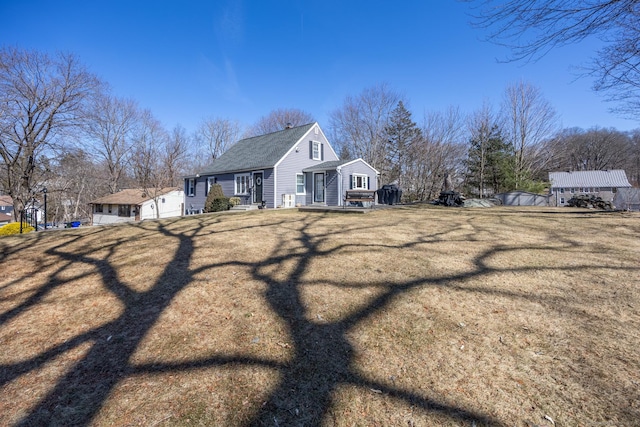 view of property exterior featuring a lawn and a shingled roof