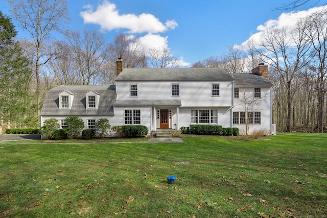 view of front of home featuring a chimney and a front lawn