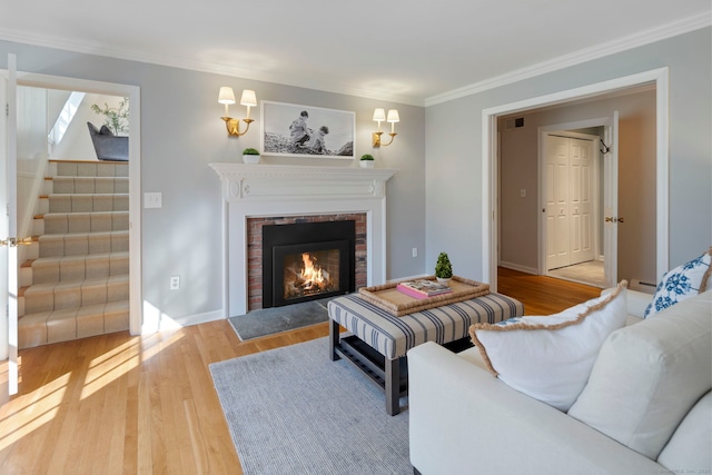 living room with stairway, wood finished floors, visible vents, a fireplace, and ornamental molding