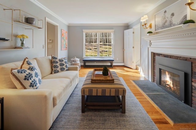 living area with a fireplace with flush hearth, crown molding, and wood finished floors