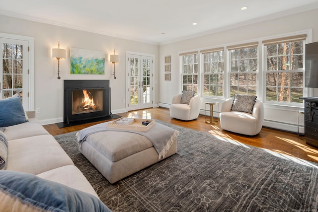 interior space featuring a baseboard heating unit, a fireplace with flush hearth, wood finished floors, and crown molding