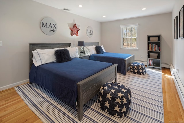 bedroom featuring a baseboard heating unit, baseboards, baseboard heating, recessed lighting, and light wood-style floors