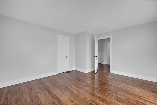 empty room featuring baseboards and wood finished floors