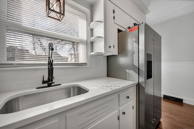 kitchen featuring a sink, visible vents, stainless steel refrigerator with ice dispenser, and light countertops