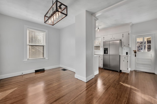 unfurnished dining area featuring visible vents, plenty of natural light, and dark wood-type flooring