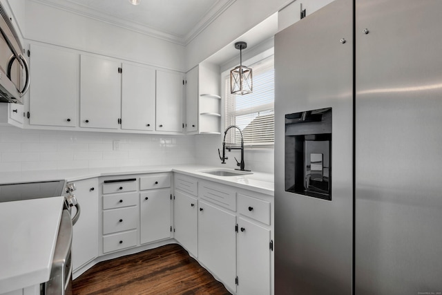 kitchen featuring crown molding, dark wood finished floors, decorative backsplash, stainless steel appliances, and a sink