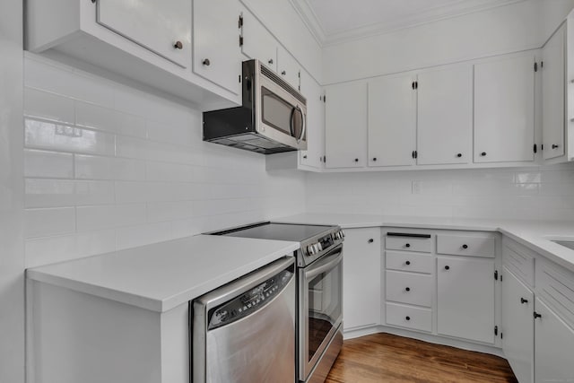 kitchen featuring dark wood-style flooring, appliances with stainless steel finishes, white cabinetry, crown molding, and tasteful backsplash