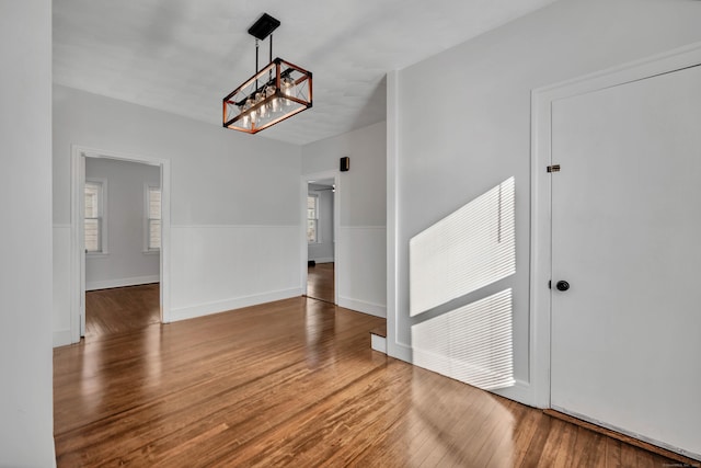 unfurnished dining area with baseboards and wood finished floors