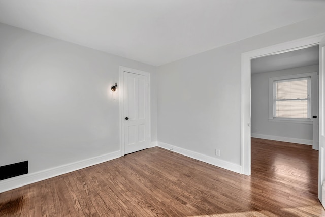 empty room featuring wood finished floors and baseboards