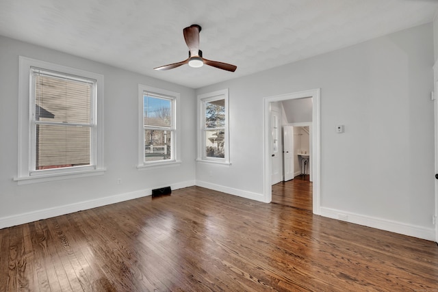 empty room with baseboards, wood finished floors, and a ceiling fan