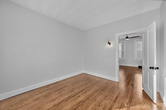 spare room featuring baseboards and wood finished floors