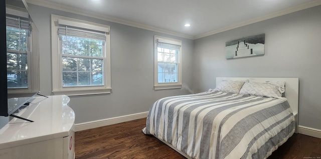 bedroom with dark wood finished floors, crown molding, and baseboards