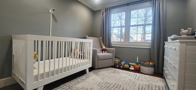 bedroom featuring a crib and crown molding