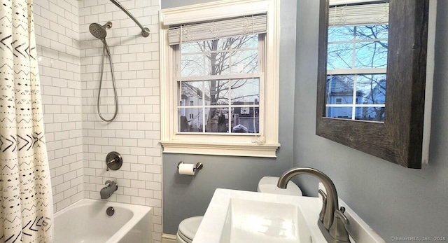 full bathroom with toilet, shower / bathtub combination with curtain, a wealth of natural light, and a sink